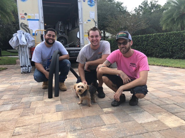 Technicians smiling with dog