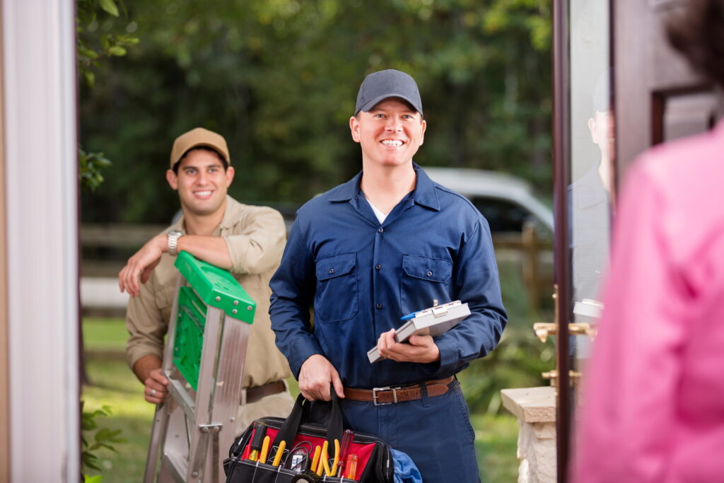 Two multi-ethnic repairmen at customer